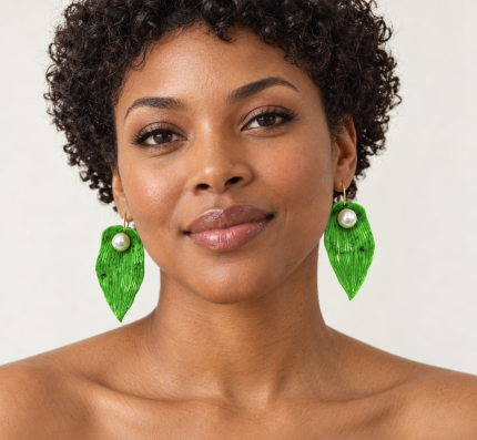 Greensleeves 2 von Maëla am Modell: leuchtend grüne, geschnitzte Blattohrringe mit weißen Perlen und goldenen Ohrhaken.